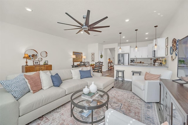 living room with ceiling fan and light wood-type flooring