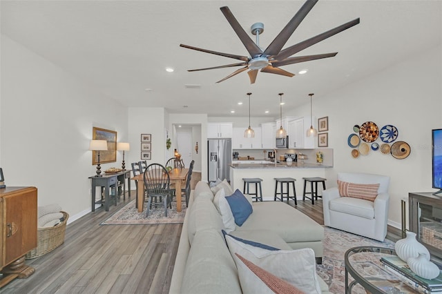 living room with light hardwood / wood-style flooring and ceiling fan