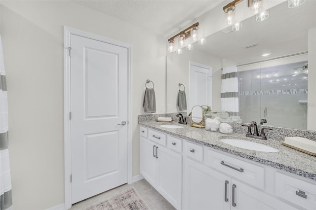 bathroom with vanity, a shower with shower door, tile patterned flooring, and a textured ceiling