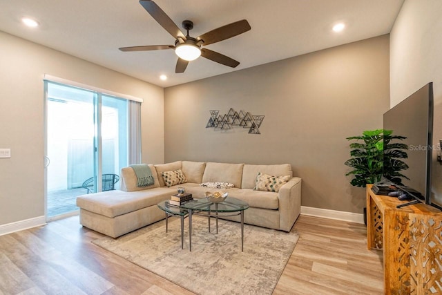 living room featuring ceiling fan and light hardwood / wood-style floors