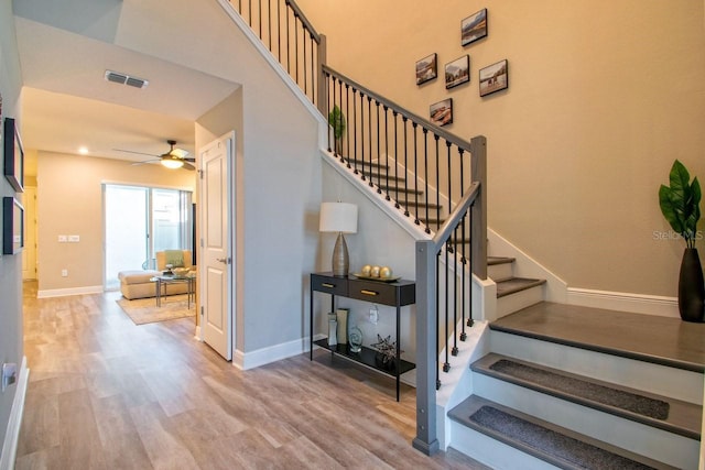 stairway featuring wood-type flooring and ceiling fan