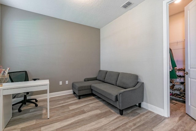 office area featuring light hardwood / wood-style flooring and a textured ceiling