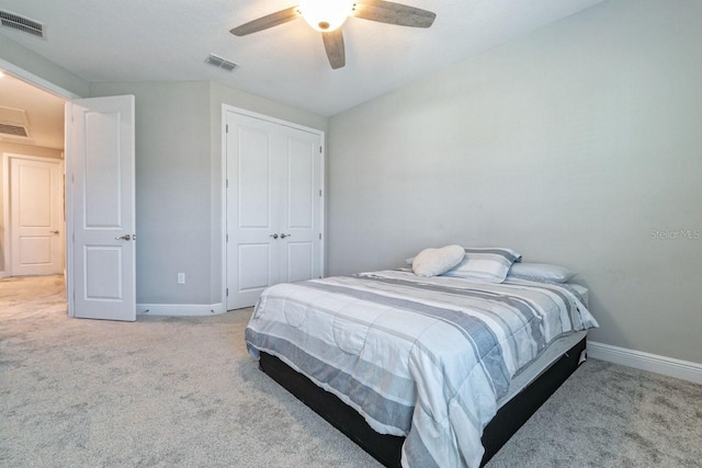 carpeted bedroom with ceiling fan and a closet