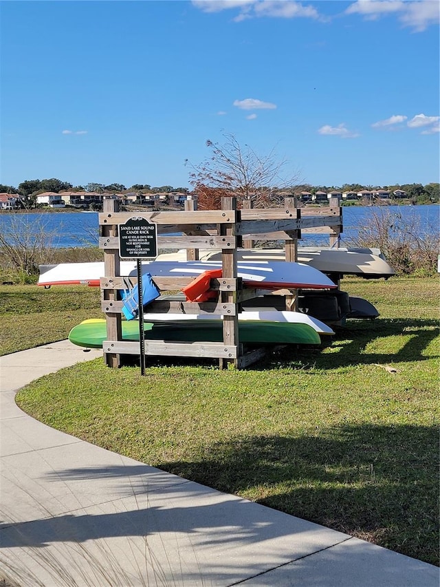 view of dock featuring a lawn and a water view