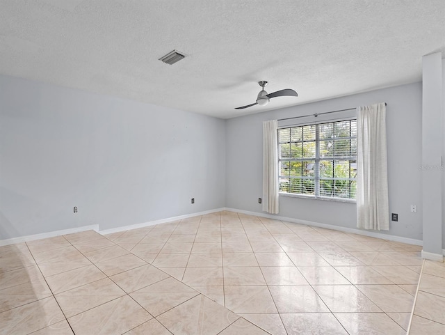 tiled spare room featuring a textured ceiling and ceiling fan