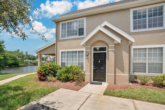 property entrance featuring a yard and a water view