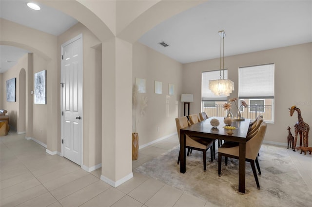 tiled dining area with a chandelier