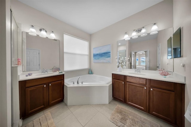 bathroom featuring tile patterned floors, tiled bath, and vanity