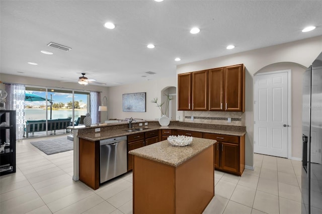 kitchen with a kitchen island, dishwasher, sink, kitchen peninsula, and light stone countertops