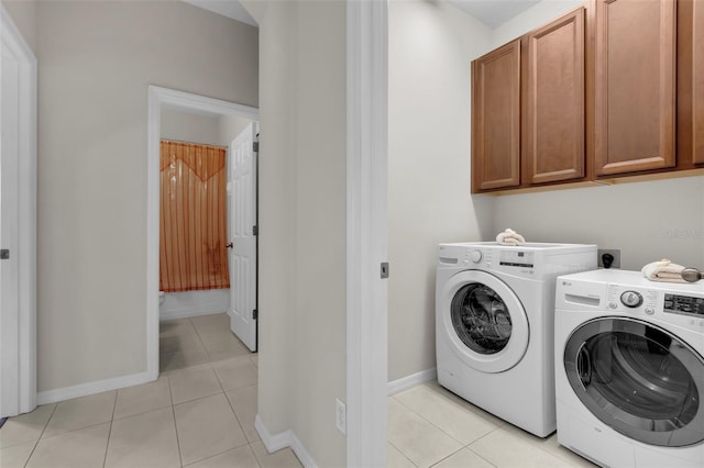 laundry area featuring cabinets, light tile patterned floors, and independent washer and dryer