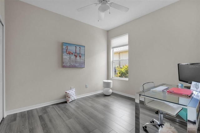 home office with wood-type flooring and ceiling fan