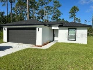 view of front of property featuring a garage and a front lawn