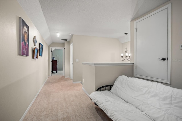 hallway featuring light carpet, baseboards, visible vents, and lofted ceiling