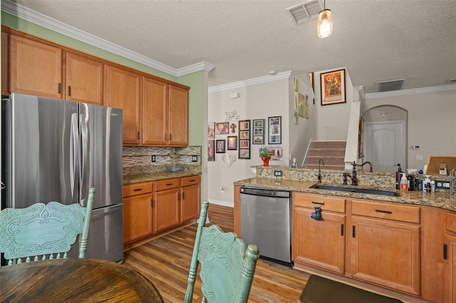 kitchen featuring stainless steel appliances, a sink, visible vents, and brown cabinets