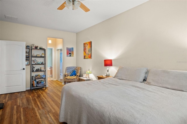 bedroom with connected bathroom, ceiling fan, and wood finished floors