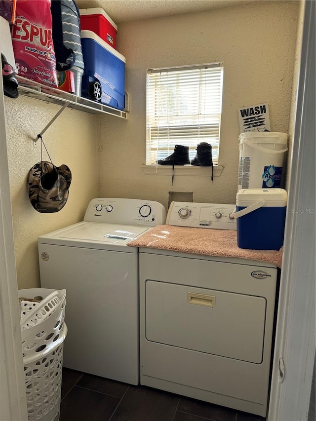 laundry room featuring dark tile patterned floors and washing machine and clothes dryer