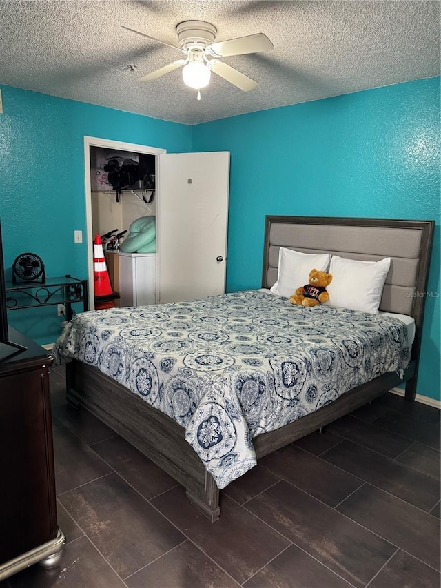 bedroom with ceiling fan and a textured ceiling