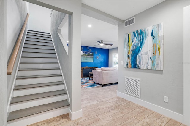 stairs featuring hardwood / wood-style floors and ceiling fan