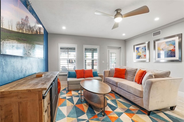 living area featuring a ceiling fan, baseboards, visible vents, and recessed lighting