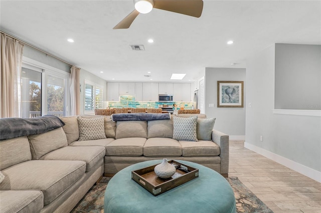 living room with light wood-style floors, baseboards, recessed lighting, and visible vents