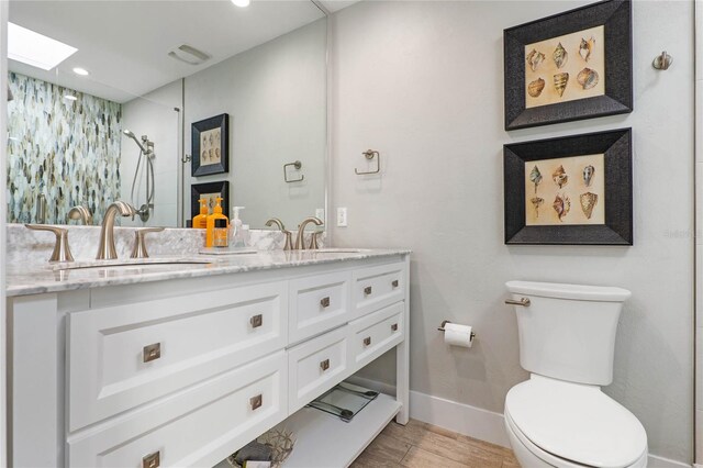 full bathroom with baseboards, a sink, a skylight, and toilet