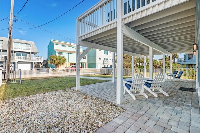view of patio featuring fence and a balcony