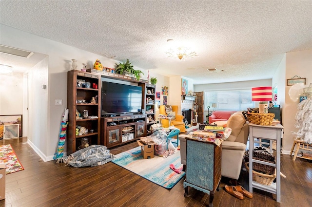 living room with dark hardwood / wood-style flooring and a textured ceiling