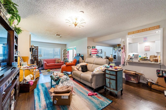 living room with dark wood-type flooring and a textured ceiling