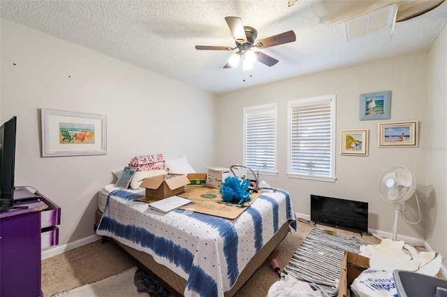 carpeted bedroom featuring a textured ceiling and ceiling fan