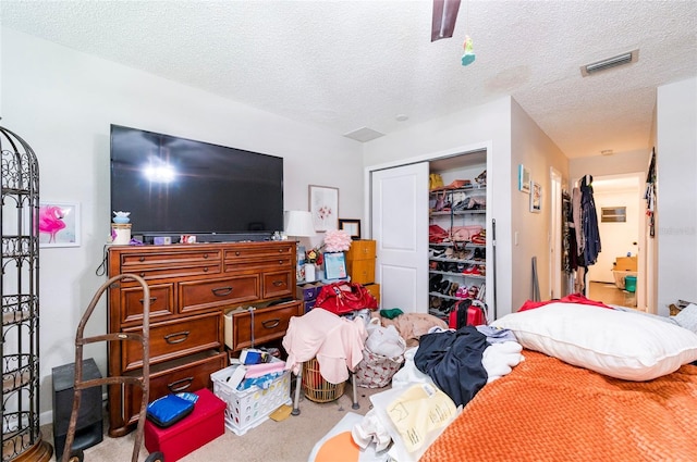 bedroom featuring ceiling fan, carpet flooring, a textured ceiling, and a closet