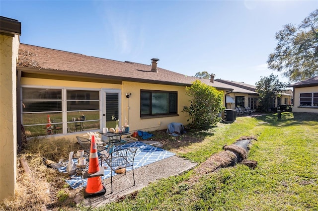 rear view of house with a yard, central AC unit, and a patio