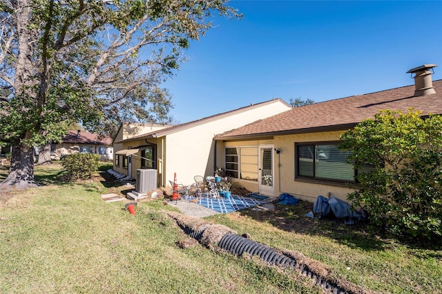 back of property with a yard, central AC unit, and a patio area