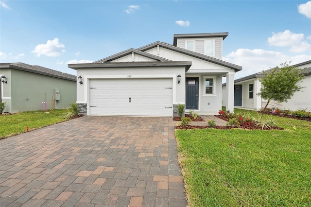 view of front of house featuring a front lawn, decorative driveway, a garage, and stucco siding