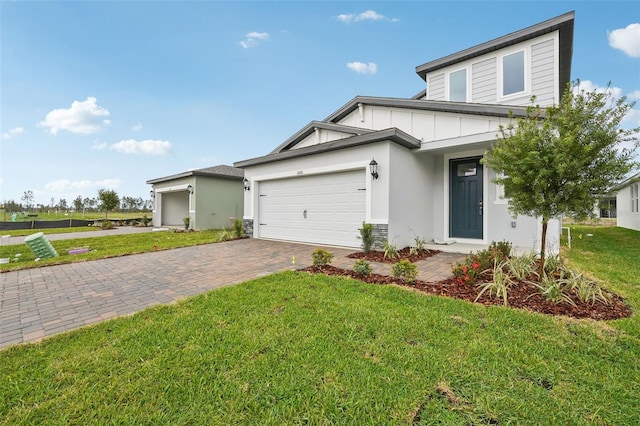 view of front of property with stucco siding, an attached garage, decorative driveway, and a front yard