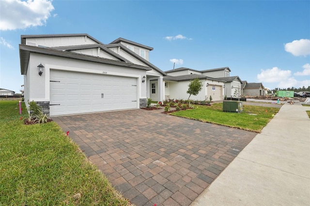 view of front of house with decorative driveway, stone siding, board and batten siding, an attached garage, and a front yard