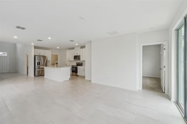 unfurnished living room featuring visible vents, recessed lighting, and a sink