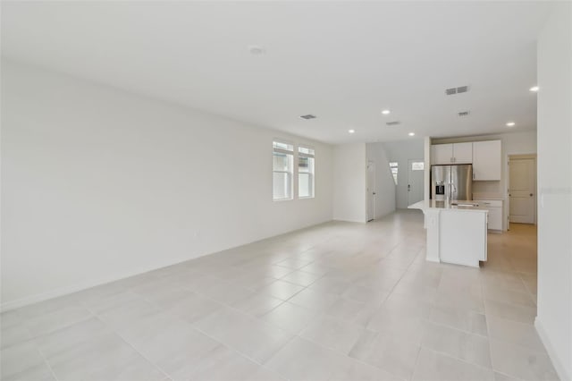 unfurnished living room with recessed lighting, visible vents, and light tile patterned floors