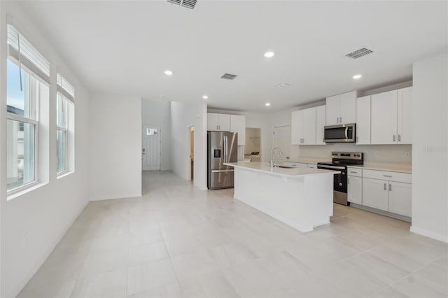 kitchen with stainless steel appliances, visible vents, white cabinets, and light countertops