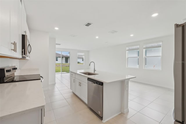 kitchen featuring white cabinetry, stainless steel appliances, light countertops, and a sink