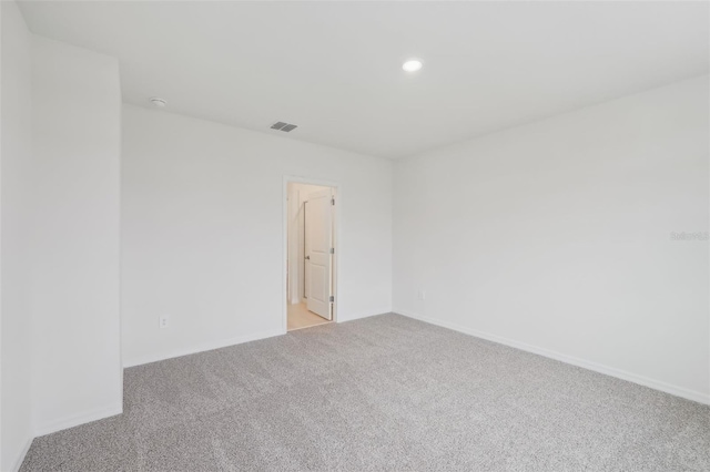 empty room with recessed lighting, baseboards, visible vents, and light carpet