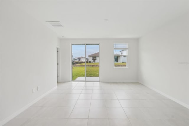 spare room with light tile patterned floors, visible vents, and baseboards