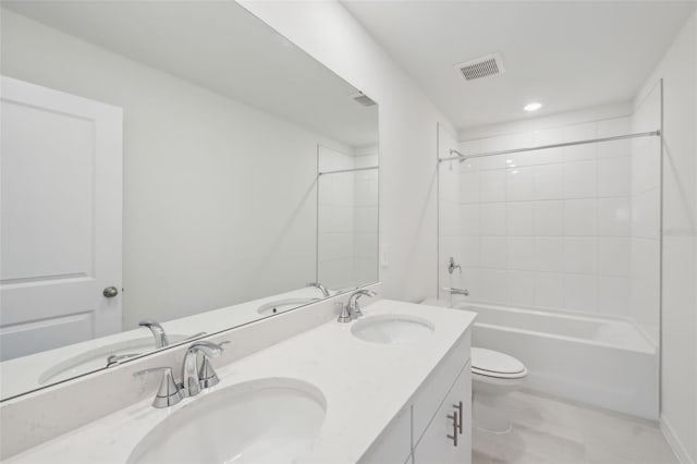 bathroom featuring double vanity, visible vents, toilet, and a sink