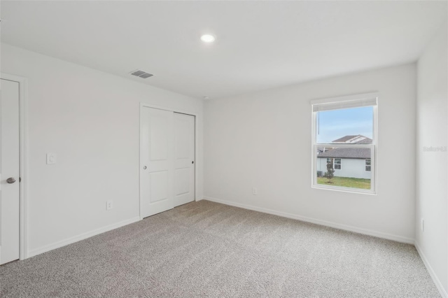 unfurnished room with recessed lighting, baseboards, visible vents, and carpet floors