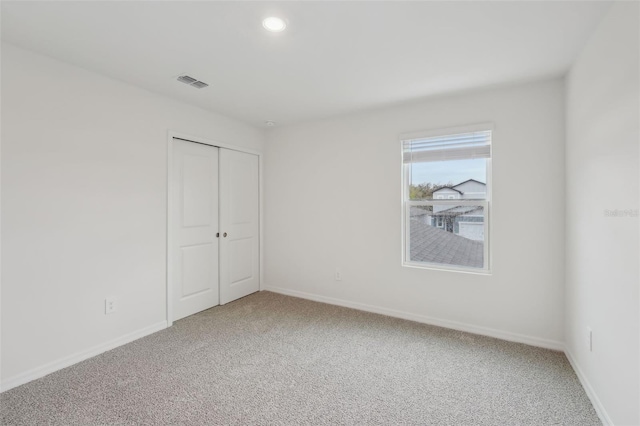 unfurnished bedroom featuring visible vents, baseboards, recessed lighting, a closet, and light colored carpet