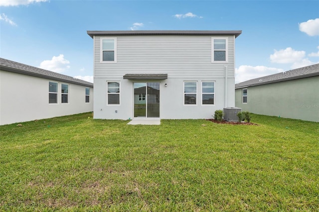 rear view of property with a lawn and central AC