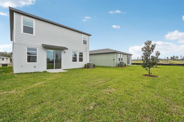 rear view of property with a lawn and central AC unit