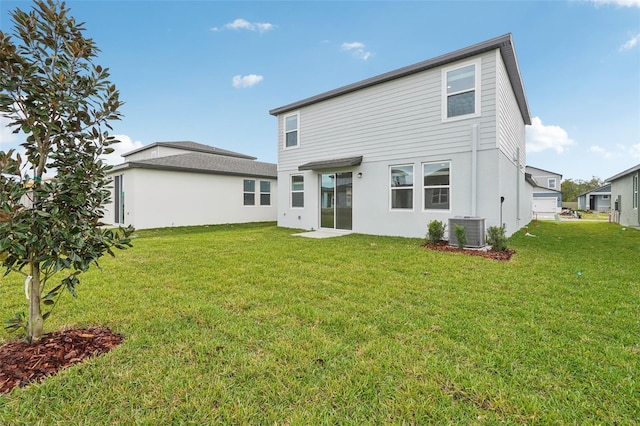 rear view of property featuring cooling unit and a lawn