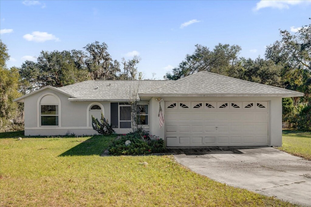 ranch-style home with a garage and a front yard