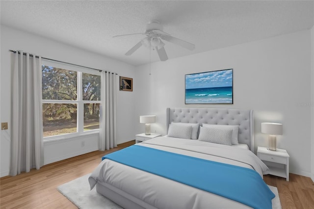 bedroom featuring multiple windows, ceiling fan, and light wood-type flooring