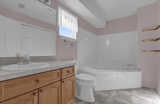 bathroom featuring a relaxing tiled tub, vanity, and toilet